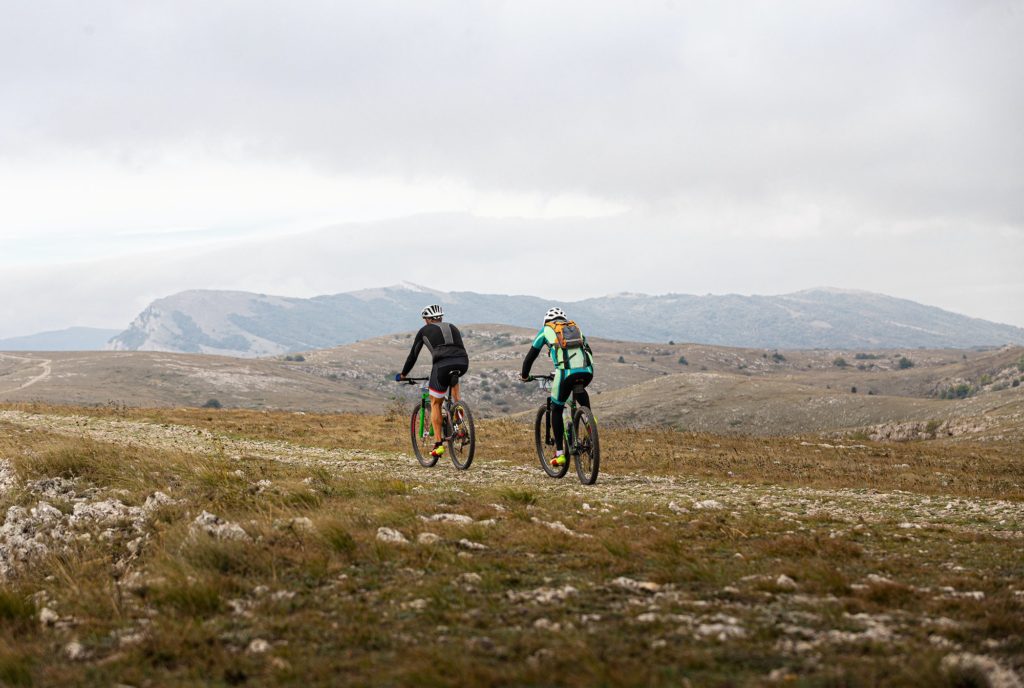 two male cyclists riding on mountain road